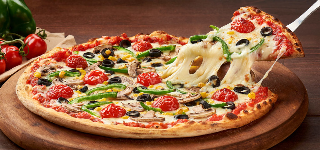 Fotografie culinara cu o felie de pizza in timp ce este ridicata de pe platou cu branza mozzarella care se intinde.